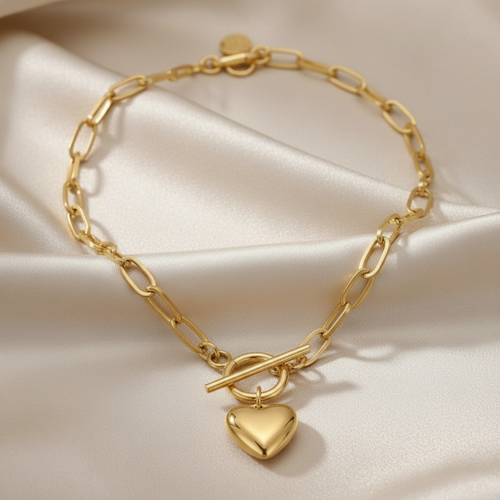 Stainless Steel, 18k gold PVD necklace with a heart-shaped charm on a beige fabric background