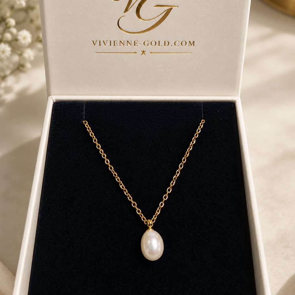 A gold chain necklace with a single white pearl pendant displayed inside an open white jewelry box with black velvet lining. The inside lid shows the brand name 'Vivienne Gold' in gold lettering.