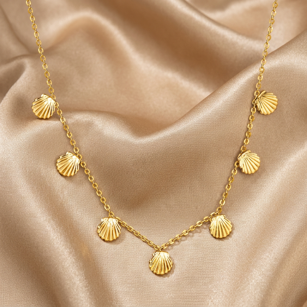 A gold chain necklace featuring seven small, textured shell-shaped charms spaced along the chain, displayed against a solid white background.